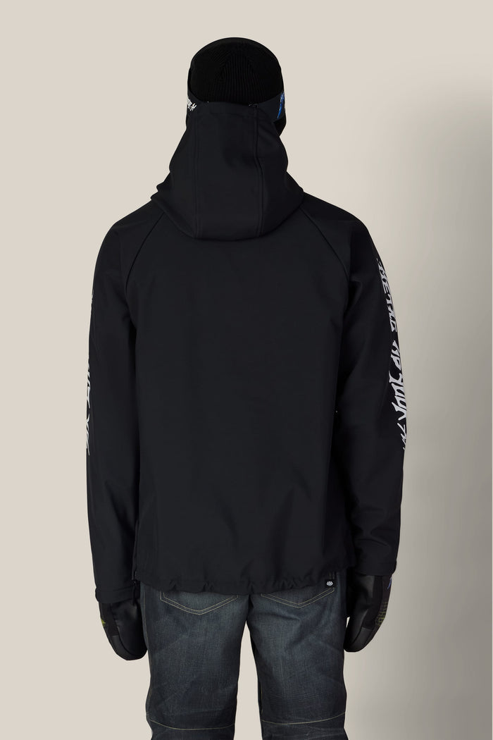 Back view of a person wearing a black 686 Men’s Metallica Waterproof Hoody with white graphic text on the sleeves, a black beanie, and dark jeans.
