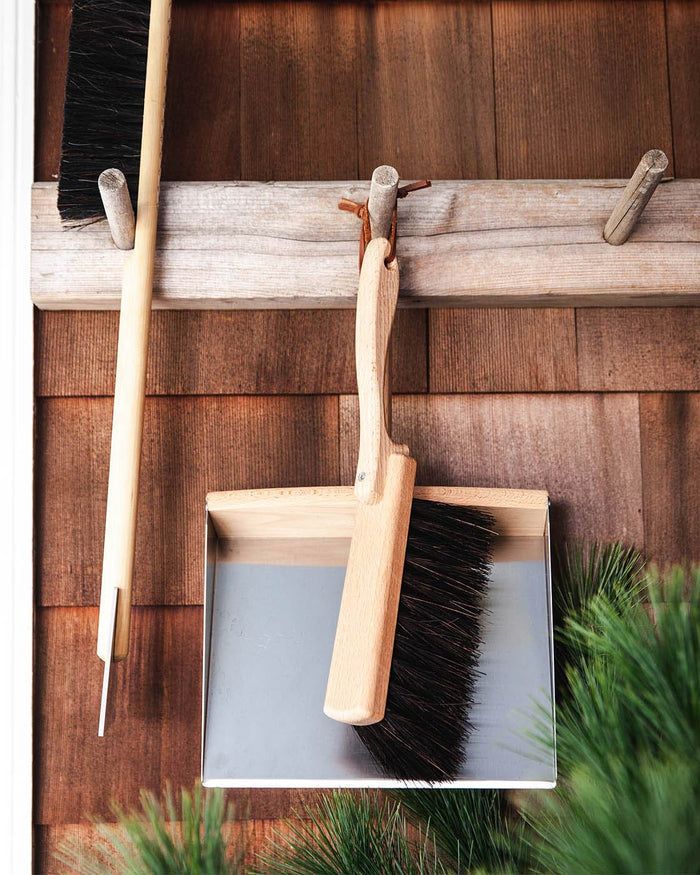Beechwood Dustpan and Arenga Brush — dustpan set hanging on a wooden wall; Redecker, curated by Farmhouse Pottery
