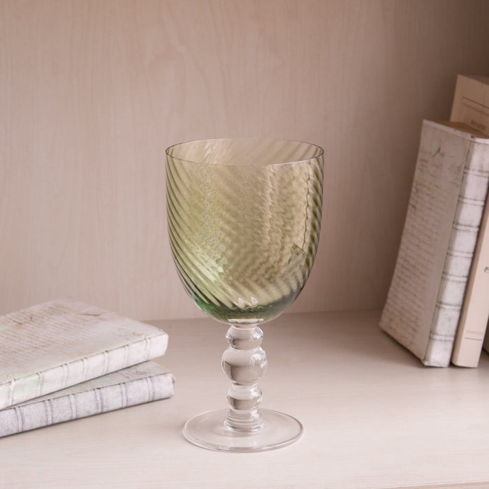 Beatriz Ball Glass French Swirl All Purpose — Single goblet beside books