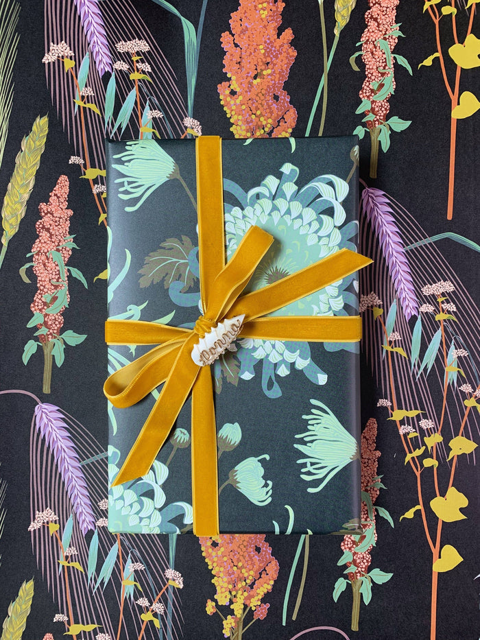 Gift wrapped in floral paper with a yellow ribbon on a matching floral background