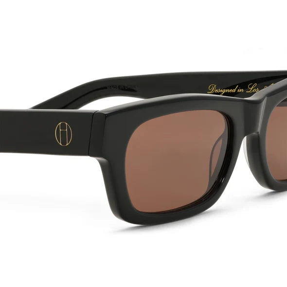 Black sunglasses with brown lenses on a white background
