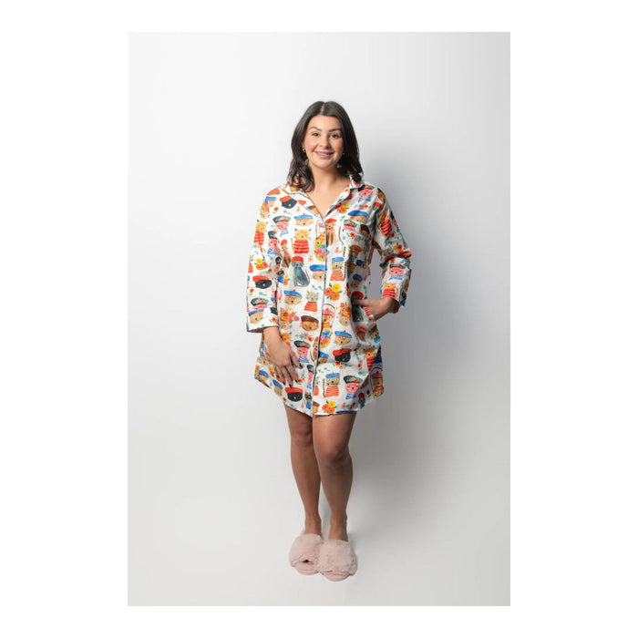 Woman wearing a colorful patterned shirt and shorts on a white background