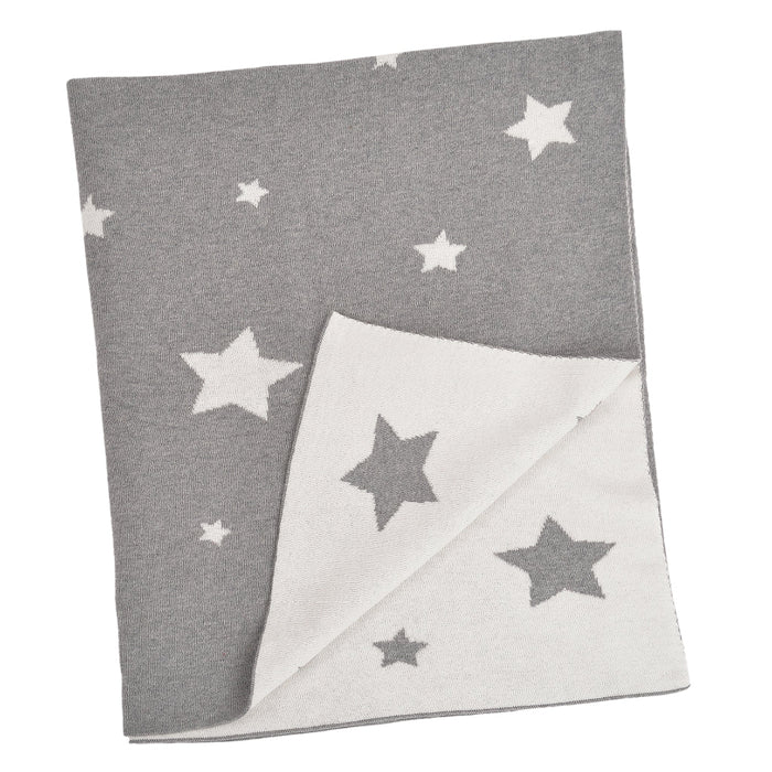 A grey baby blanket with white stars and a solid white corner, laid out flat.