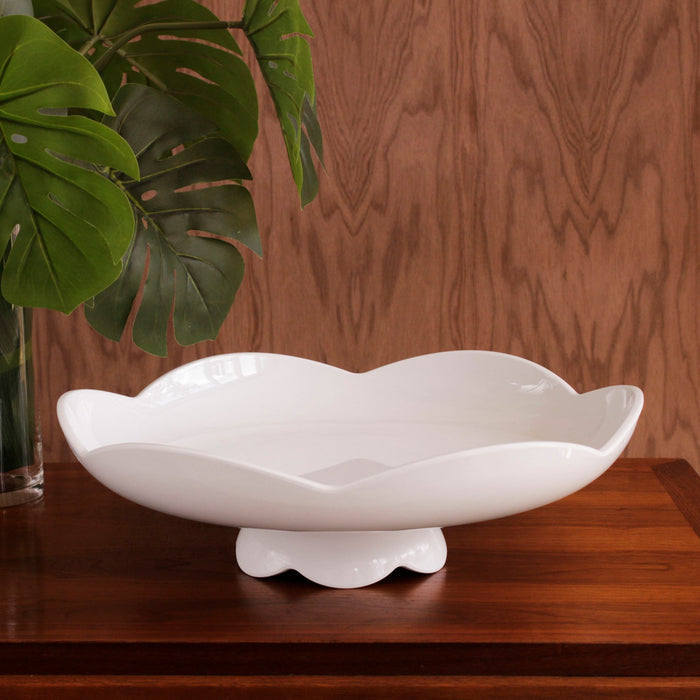 Beatriz Ball Vida Amelia Pedestal Cake Plate White — Empty cake stand beside large green leaves